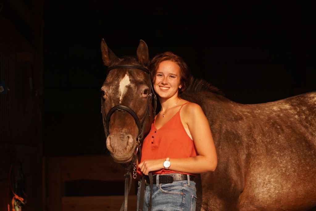 Kaia elise, a digital marketer stands next to her horse